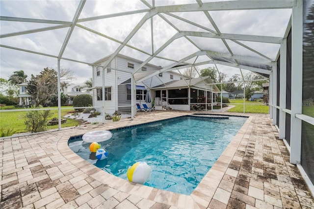 outdoor pool featuring a patio area, glass enclosure, and a lawn