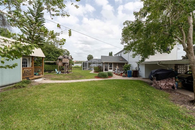 view of yard featuring an outdoor structure, a lanai, and a playground