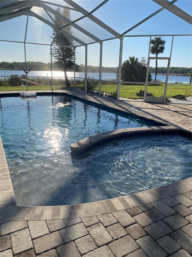 view of pool with a lanai, a pool with connected hot tub, and a patio