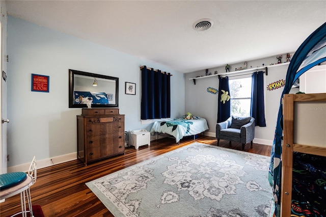 bedroom featuring visible vents, baseboards, and wood finished floors