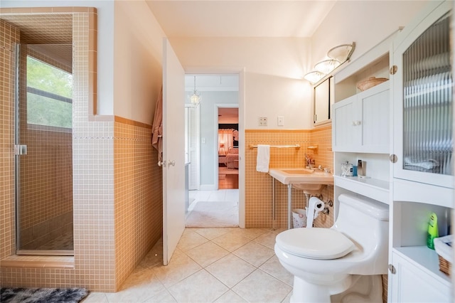 full bathroom featuring tile patterned flooring, a shower stall, connected bathroom, wainscoting, and tile walls