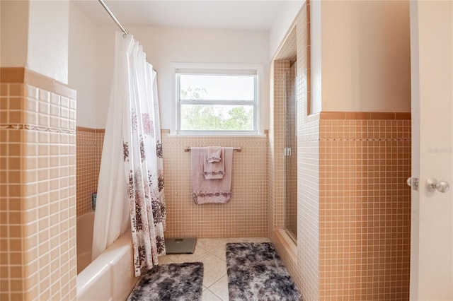 bathroom with tile patterned floors, a wainscoted wall, tile walls, and shower / bath combo