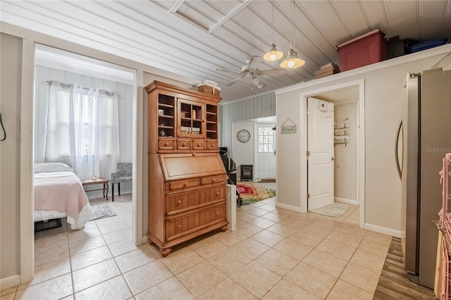 kitchen featuring baseboards, ceiling fan, ornamental molding, freestanding refrigerator, and light tile patterned flooring