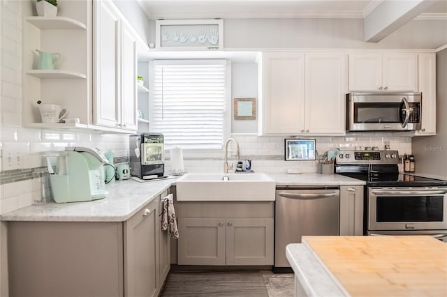 112 E Graham Park Dr, Haines City, FL 33844 - kitchen featuring stainless steel appliances, open shelves, crown molding, decorative backsplash, and white cabinetry