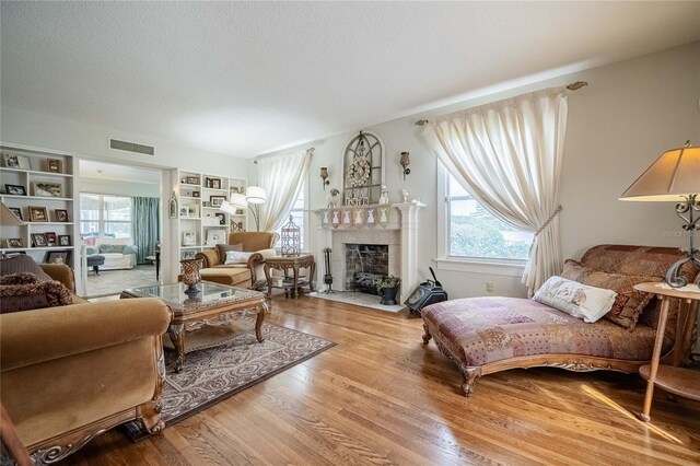 112 E Graham Park Dr, Haines City, FL 33844 - living room featuring wood finished floors, a fireplace with flush hearth, a textured ceiling, and built in features