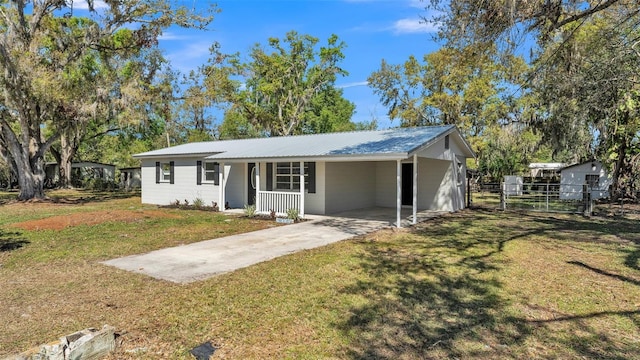 ranch-style home featuring fence, concrete driveway, a carport, a front lawn, and metal roof