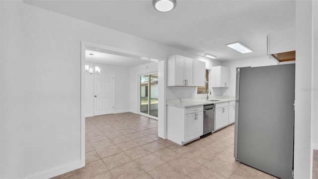 kitchen with a sink, stainless steel appliances, white cabinetry, and light countertops