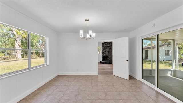 empty room featuring baseboards, an inviting chandelier, light tile patterned flooring, and crown molding