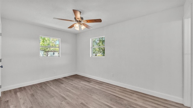 unfurnished room with a healthy amount of sunlight, light wood-type flooring, and baseboards