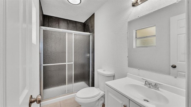 bathroom with vanity, a stall shower, a textured ceiling, toilet, and a textured wall