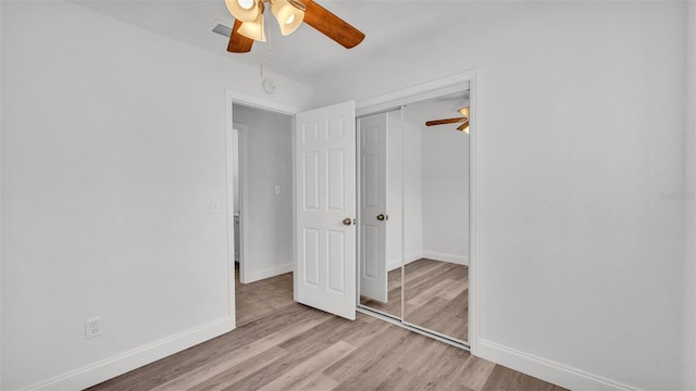 unfurnished bedroom with light wood-style flooring, baseboards, a closet, and ceiling fan