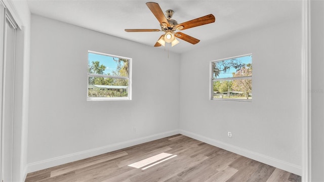 unfurnished bedroom with a closet, light wood-style flooring, a ceiling fan, and baseboards