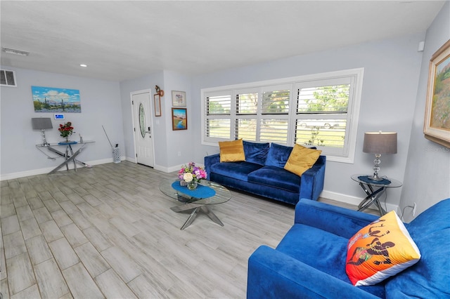 living area with visible vents, baseboards, and wood finished floors