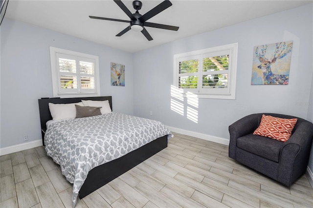 bedroom featuring baseboards, multiple windows, ceiling fan, and wood tiled floor