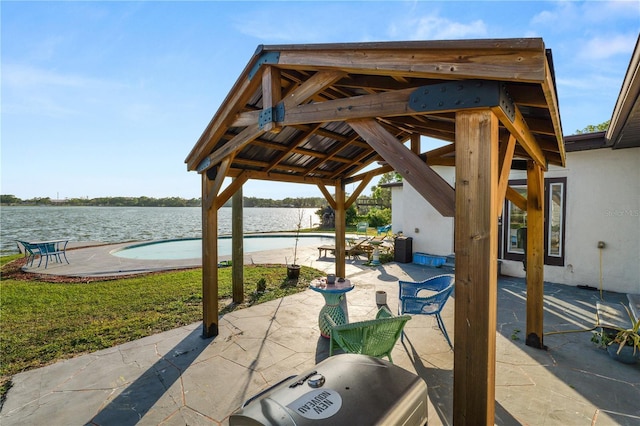 view of patio / terrace with an outdoor pool, a water view, and a gazebo