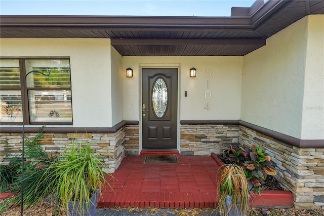 entrance to property with stucco siding and stone siding