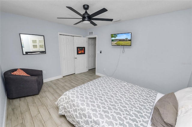 bedroom with light wood finished floors, visible vents, baseboards, a closet, and a ceiling fan