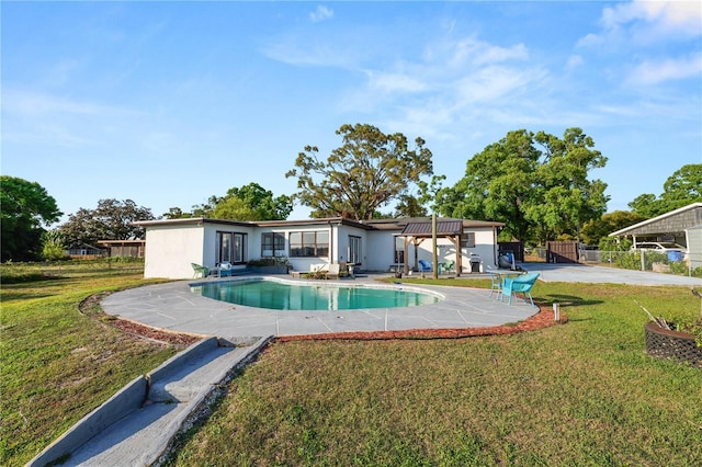 pool with a patio, a lawn, and fence