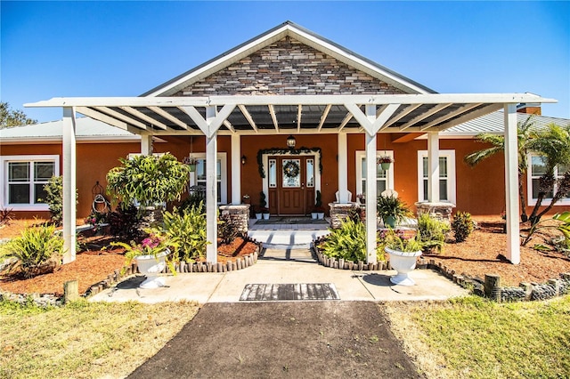 view of front of property featuring covered porch, metal roof, and stucco siding