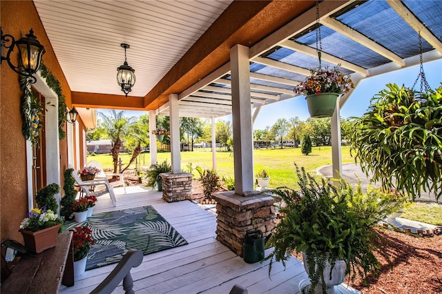 wooden deck with a lawn, a porch, and a pergola