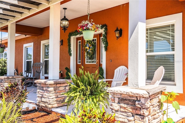 entrance to property with stucco siding and covered porch