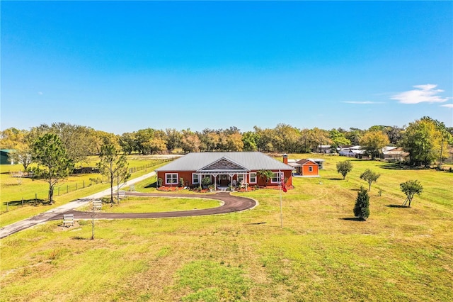 view of front of property with driveway, an outdoor structure, a front lawn, and fence