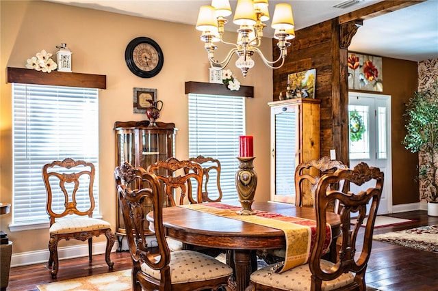 dining room with baseboards, a notable chandelier, and wood finished floors