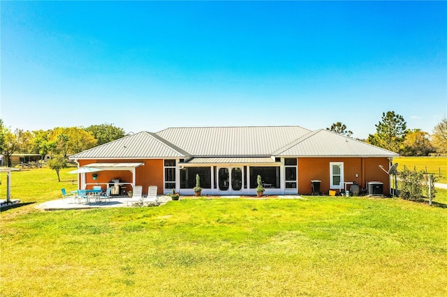 back of property featuring a patio, cooling unit, a standing seam roof, a yard, and metal roof