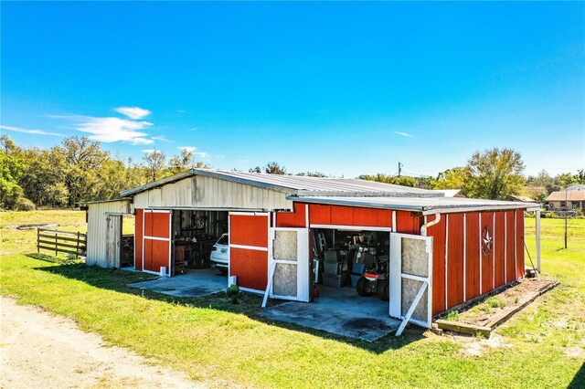 view of pole building featuring a yard and fence