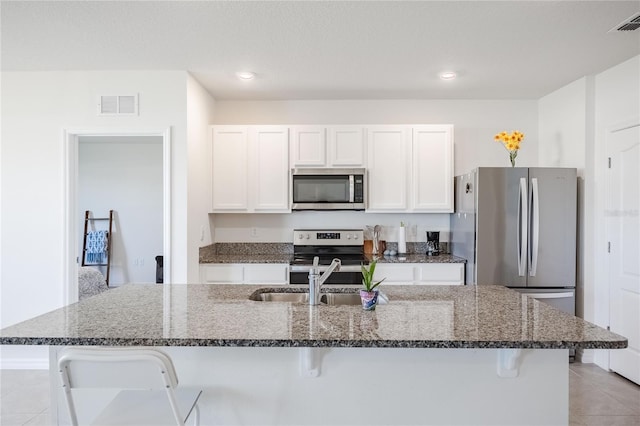 kitchen with a sink, visible vents, appliances with stainless steel finishes, and a breakfast bar