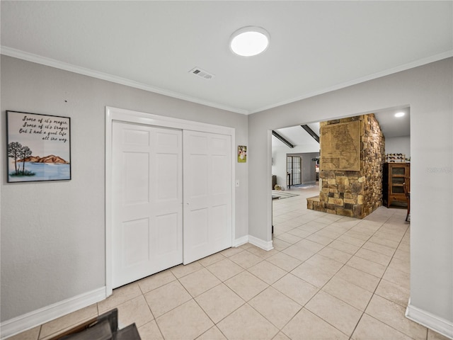 entryway with light tile patterned floors, visible vents, crown molding, and baseboards