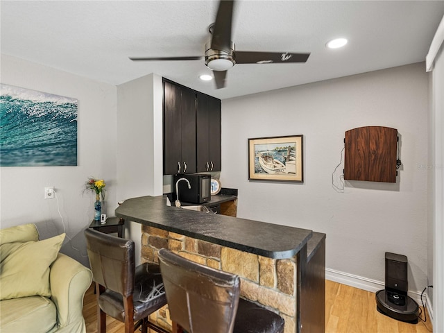 office space featuring light wood-style flooring, a sink, recessed lighting, baseboards, and ceiling fan