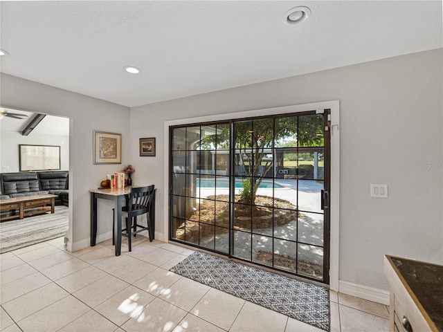 doorway featuring light tile patterned floors, baseboards, ceiling fan, and recessed lighting