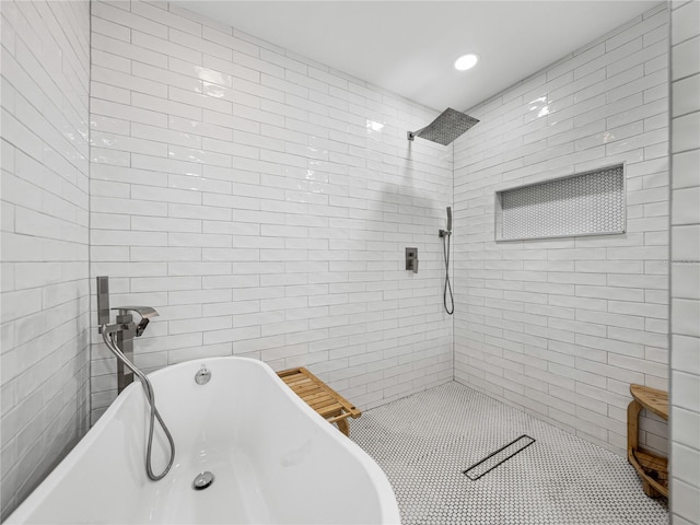 full bath with a tile shower, tile walls, and a freestanding tub