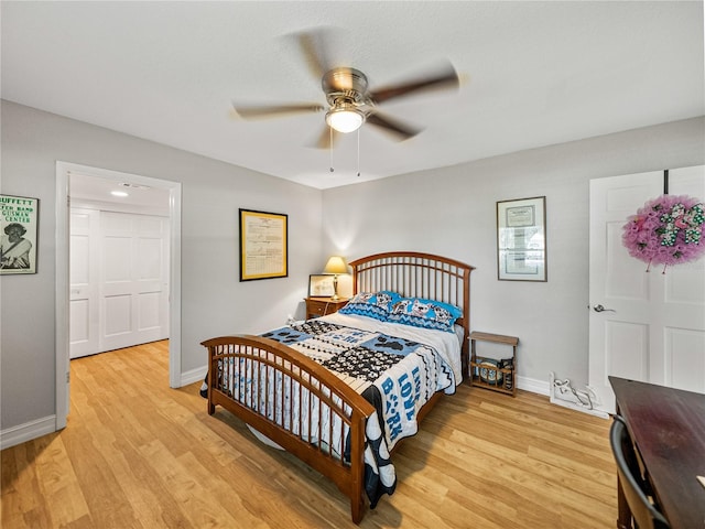bedroom featuring light wood-style flooring, a ceiling fan, and baseboards