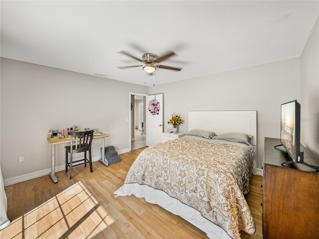 bedroom featuring ceiling fan, visible vents, baseboards, and wood finished floors