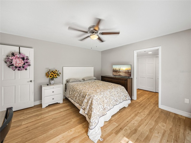 bedroom featuring baseboards, light wood-style floors, and a ceiling fan