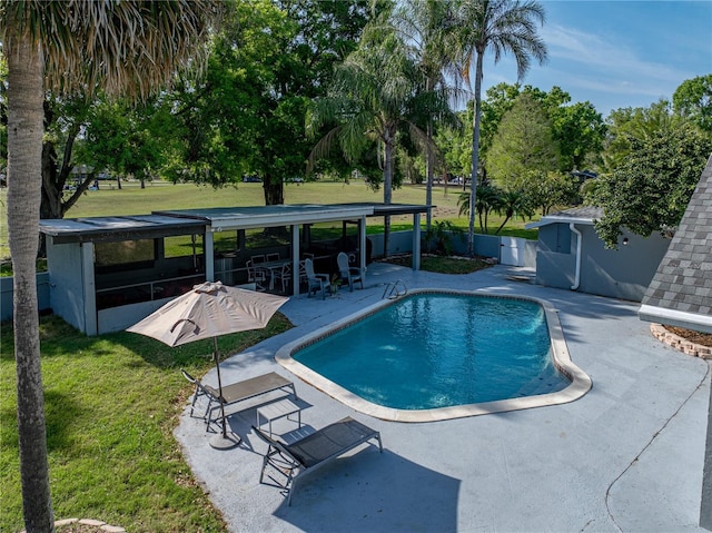 view of swimming pool featuring a lawn, fence, a patio, and a fenced in pool