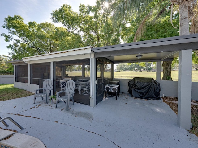 view of patio / terrace featuring a sunroom and a grill