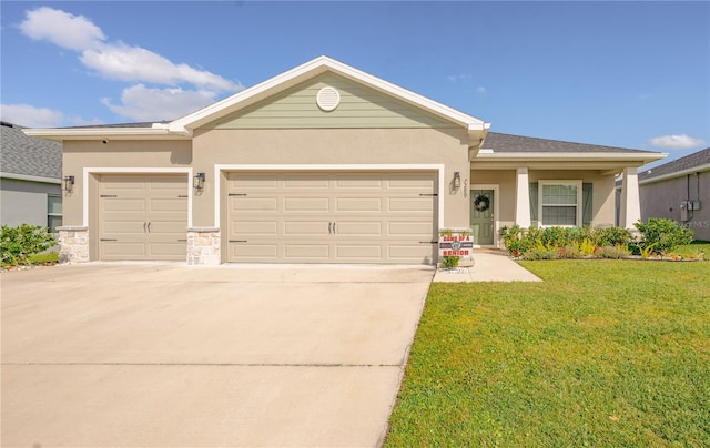 single story home featuring a front lawn, an attached garage, driveway, and stucco siding