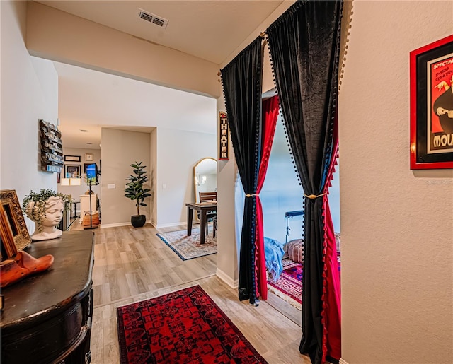 interior space with arched walkways, visible vents, baseboards, and wood finished floors