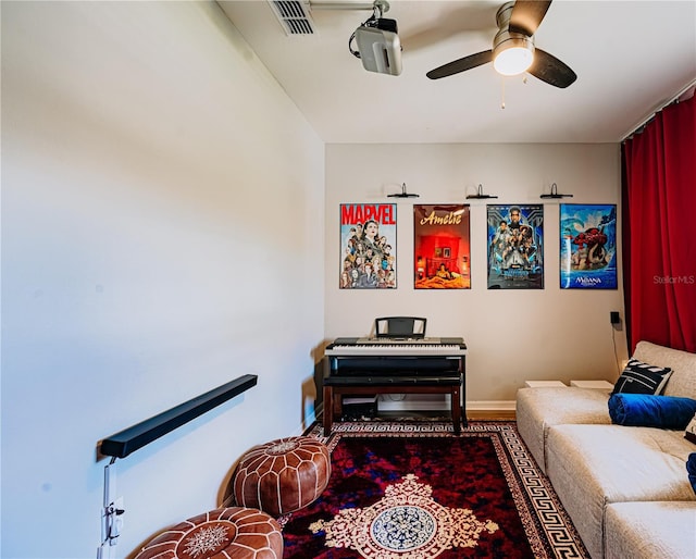 sitting room with visible vents, baseboards, and a ceiling fan