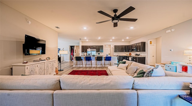 living room featuring visible vents, recessed lighting, a ceiling fan, and light wood-type flooring