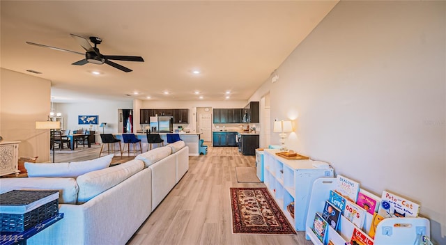 living area with recessed lighting, ceiling fan, and light wood finished floors