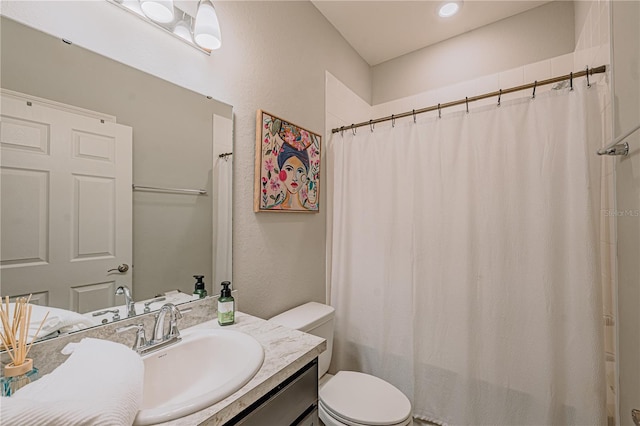 full bath featuring curtained shower, toilet, vanity, and a textured wall