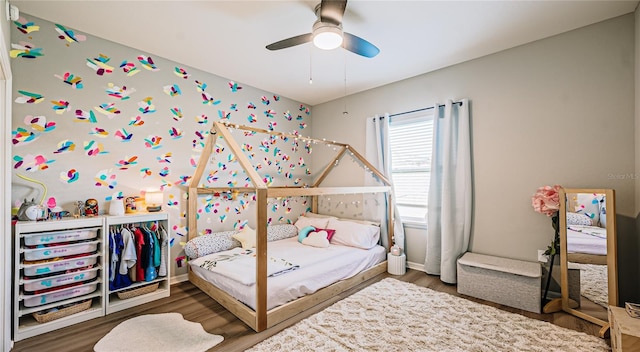 bedroom with ceiling fan, baseboards, and wood finished floors