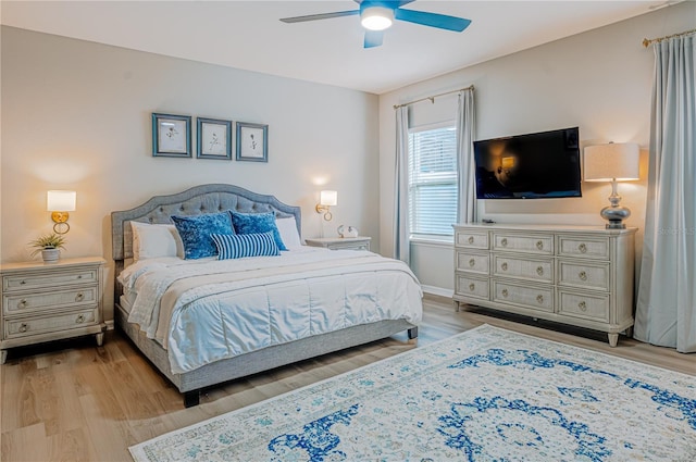 bedroom with light wood finished floors, baseboards, and a ceiling fan