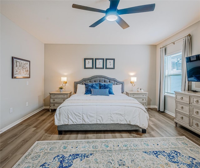 bedroom featuring a ceiling fan, baseboards, and wood finished floors