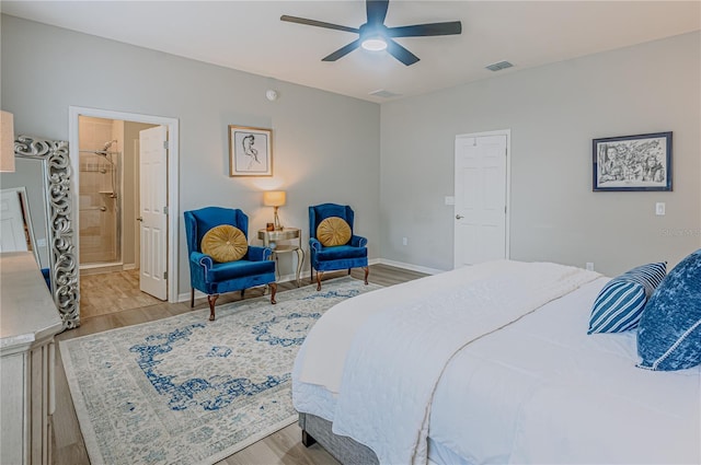 bedroom featuring visible vents, a ceiling fan, wood finished floors, connected bathroom, and baseboards