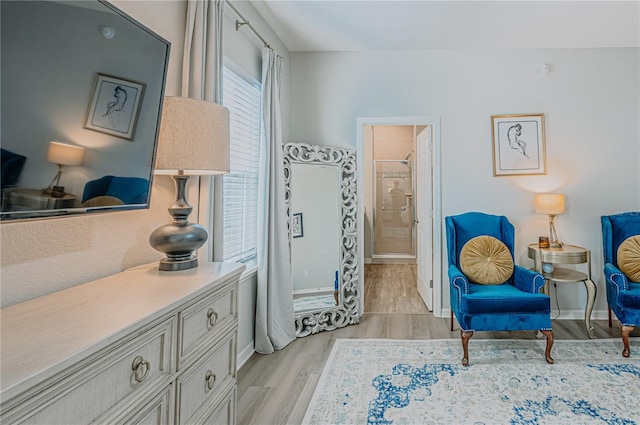 sitting room with baseboards and light wood-type flooring